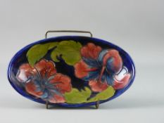 A MOORCROFT 'HIBISCUS' OVAL DISH, cobalt ground, 23.5 cms diameter, faint impressed factory marks to