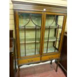 AN EDWARDIAN INLAID MAHOGANY DISPLAY CABINET, twin five panel glazed doors and linen covered