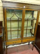 AN EDWARDIAN INLAID MAHOGANY DISPLAY CABINET, twin five panel glazed doors and linen covered