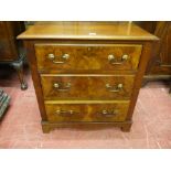 A NEAT MAHOGANY AND WALNUT THREE DRAWER CHEST, inset panel sides with shaped apron and corner