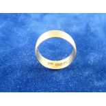 A TWENTY TWO CARAT GOLD WIDE WEDDING BAND, 3.5 grms