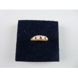AN UNMARKED GOLD DRESS RING having three small rubies and two diamonds, 3 grms total