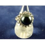 AN EIGHTEEN CARAT WHITE GOLD DRESS RING having a large dark pearl cluster with sixteen surrounding