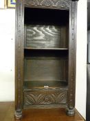 A REPRODUCTION ANTIQUE STYLE BOOKCASE, carved decoration to front with two open shelves and lower