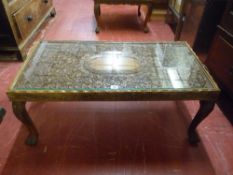 AN INDIAN CARVED HARDWOOD COFFEE TABLE, 20th Century with glass inset top, deep carved bird and leaf