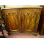 A VICTORIAN MAHOGANY TWO DOOR CUPBOARD with interior sliding trays, the moulded edge top over twin