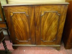 A VICTORIAN MAHOGANY TWO DOOR CUPBOARD with interior sliding trays, the moulded edge top over twin