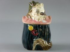 A CONTINENTAL MAJOLICA TOBACCO JAR in the form of a dog in costume with a pink ruff, 13 cms high,