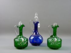 A PAIR OF MARY GREGORY GREEN GLASS DECANTERS decorated with a winged cherub amongst flora, (stoppers