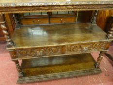 A 20th CENTURY JACOBEAN OAK DUMB WAITER, three shelf with mask carved railback, twist column