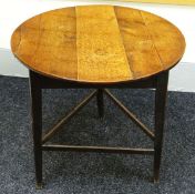 AN OAK CRICKET TABLE with plank top and simple base, circa 1810, 74cms diam