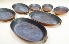 A SET OF SEVEN OVAL COPPER FISH PANS comprising four 37cms long and three 27cms long, each with