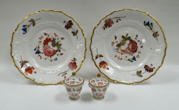 A PAIR OF PORCELAIN PLATES having moulded borders and with sprays of flowers, each with red