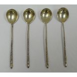 A SET OF FOUR RUSSIAN SILVER COFFEE SPOONS with spiral stems and floral engraved bowls with