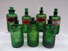 SEVEN GREEN PHARMACEUTICAL BOTTLES, all of similar size, each with stoppers and four with original