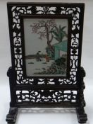 A FAMILLE VERT TABLE SCREEN in a fretwork hardwood stand, the porcelain panel depicting two