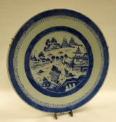 A CHINESE BLUE AND WHITE CHARGER the interior decorated with a village scene with pagodas and boats,