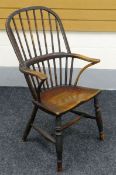 AN ELM WINDSOR ELBOW CHAIR on turned supports and having a two stage stick back and curved arms