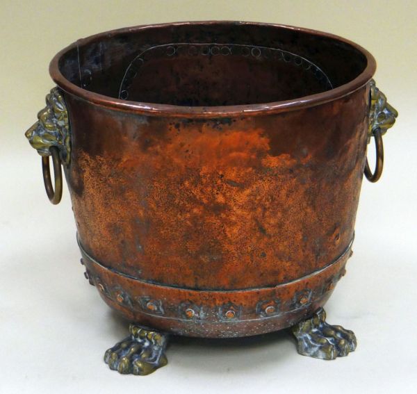 A CIRCULAR COPPER AND BRASS COAL BUCKET the body in copper and having brass lion ring handles and