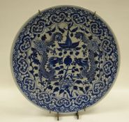 A CHINESE BLUE AND WHITE PLATE profusely decorated with a pair of opposing dragons, lotus flowers