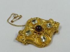 A VICTORIAN BROOCH IN BELIEVED GOLD (unmarked), decorated with four green stones and a single red