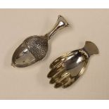 TWO NOVELTY SILVER CADDY SPOONS in the form of a hand, by Francis Howard, Sheffield 1979, 0.48ozs;