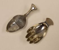 TWO NOVELTY SILVER CADDY SPOONS in the form of a hand, by Francis Howard, Sheffield 1979, 0.48ozs;