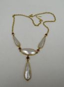 A MOTHER-OF-PEARL & GARNET NECKLACE believed 9ct yellow gold