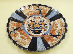 LARGE IMARI CHARGER with lobed borders and fluted interior and having three outer landscape panels