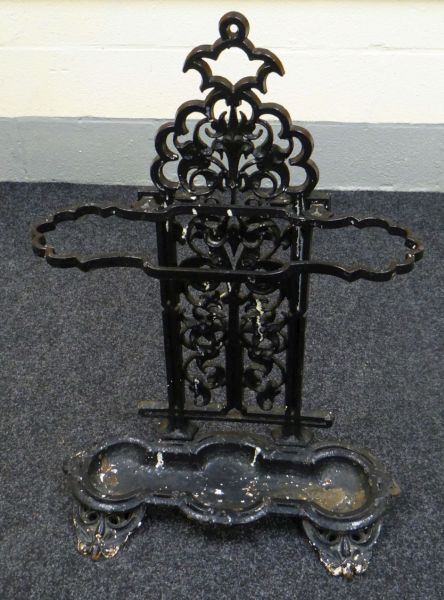 A VICTORIAN PAINTED CAST IRON UMBRELLA STAND the tray formed by three conjoined sections and with