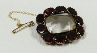 A VICTORIAN LOCKET with glass case surrounded by ten oval red stones