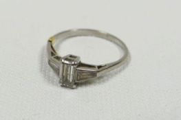 A BAGUETTE DIAMOND RING with tapered diamonds to each shoulder, 2.76gms