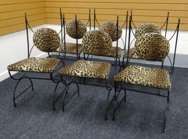 A SET OF SIX SALON CHAIRS with looping metallic frames and faux-leopard skin covered seats and