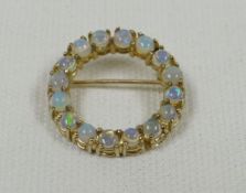 A GOLD HOOP BROOCH SET WITH SIXTEEN OPALS, marked 9ct, 3.34gms