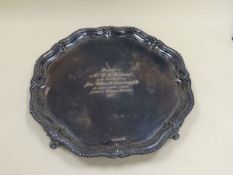 A VERY LARGE SILVER TRAY of pie-crust form with elevated gadrooned border and raised on four