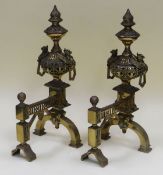 A GOOD PAIR OF BRASS FIRE DOGS with elaborate decorative design and having griffin handles