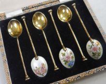 A CASED SET OF ENAMELLED SILVER-GILT SPOONS the back of the bowls finely enamelled with studies of