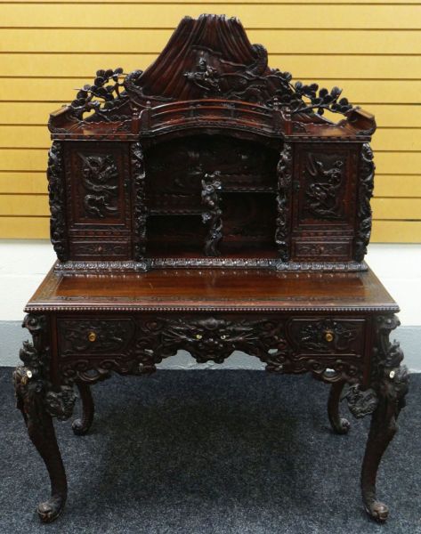 A JAPANESE MEIJI CARVED DESK with cabinet and recess top and base of two drawers, heavily carved