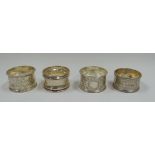 FOUR SILVER NAPKIN RINGS including a pair of leaf-decorated, 3.15ozs