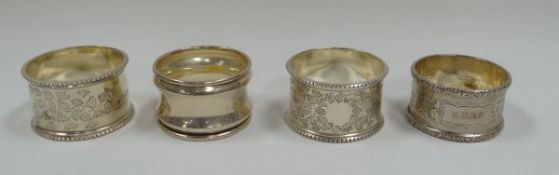 FOUR SILVER NAPKIN RINGS including a pair of leaf-decorated, 3.15ozs