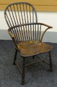 A SMALL WINDSOR ELBOW-CHAIR in elm and having a shaped seat and two stage stick back circa 1820