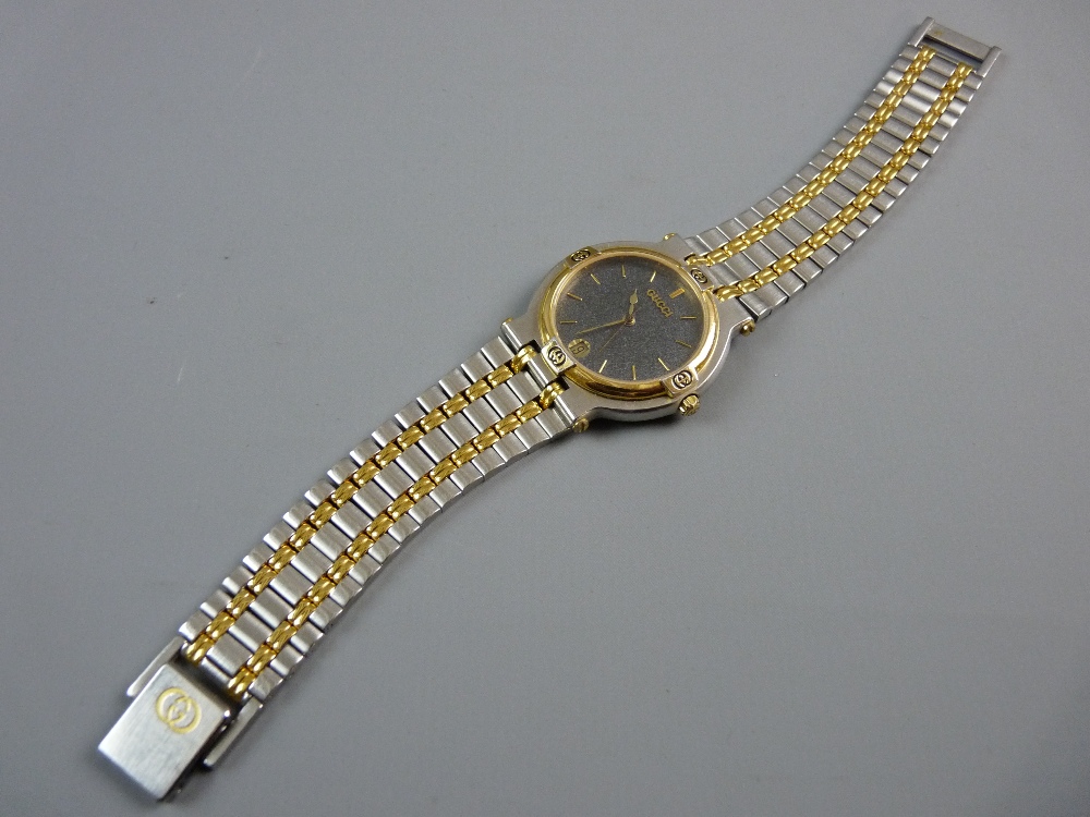 A LADY'S OR GENT'S GUCCI CALENDAR WRISTWATCH, stainless steel and yellow metal decorated having a