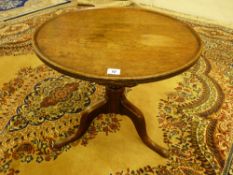 A CIRCULAR TRAY TOP TRIPOD TABLE on a short shaped centre column and three curved and pad