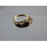 A NINE CARAT GOLD DRESS RING having a centre garnet with two small flanking opals and a smaller