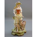 A CONTINENTAL SCHOOL PARIAN FIGURINE of a standing country girl with a young deer at foot on a