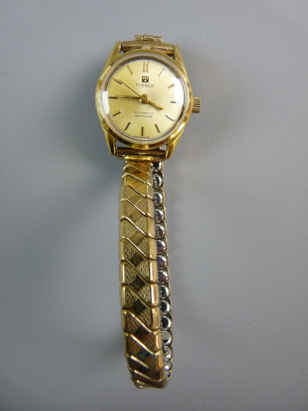 A TISSOT LADY'S AUTOMATIC C-STAR WRISTWATCH, entirely gold coloured with expanding strap