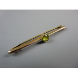 AN UNMARKED GOLD BAR BROOCH with single round cut peridot?, 2 grms gross