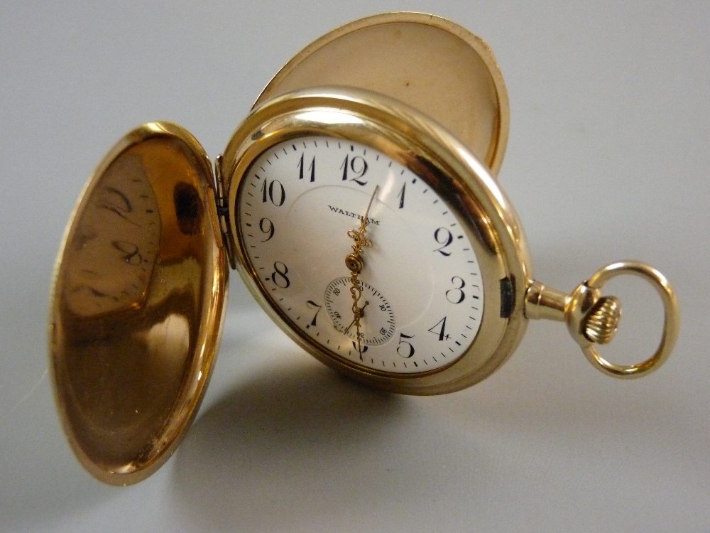 A WALTHAM FULL HUNTER POCKET WATCH, the gold coloured case fully chase decorated, the white interior