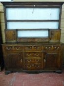 AN EARLY 19th CENTURY OAK WELSH DRESSER, the rack having reeded end columns to a small cupboard at