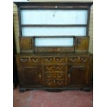 AN EARLY 19th CENTURY OAK WELSH DRESSER, the rack having reeded end columns to a small cupboard at